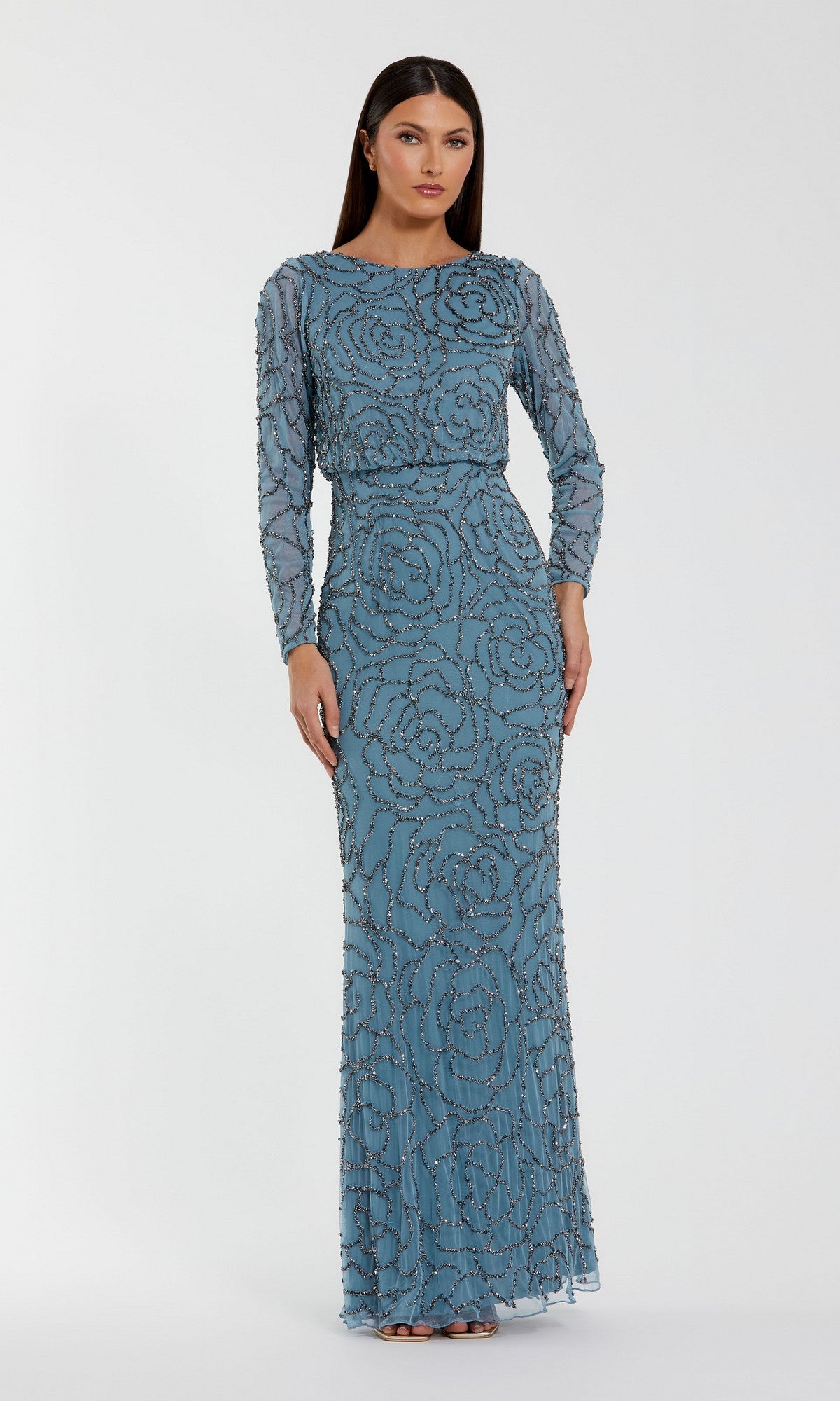 A woman wearing the Long Formal Dress: Mac Duggal 6189—a floor-length, smoky blue gown embellished with beaded swirl patterns—stands against a plain white background.